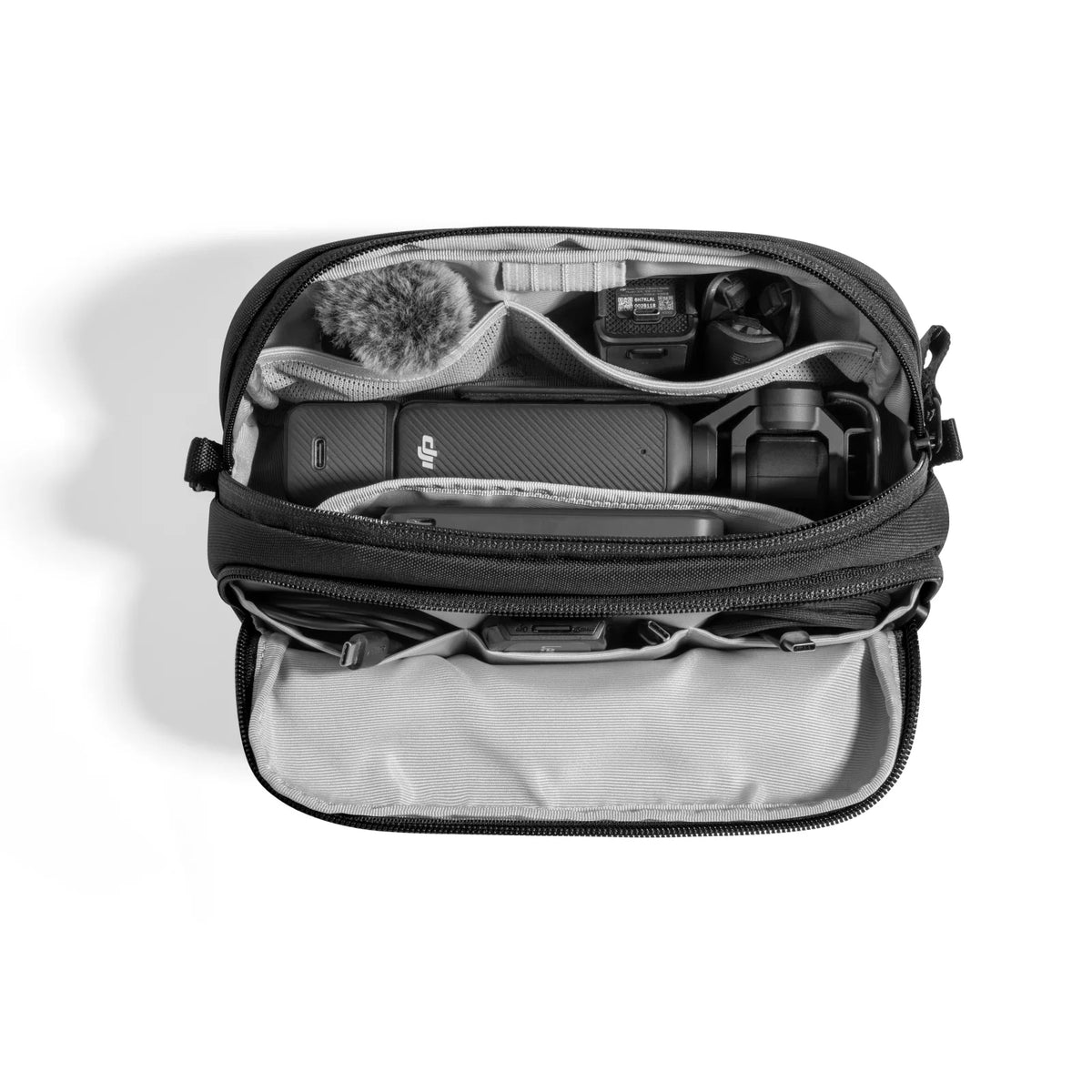 Open black and gray bag with various items on a white background