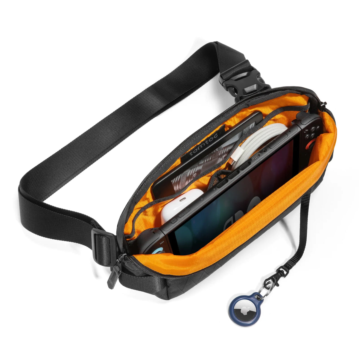 A tomtoc X-Pac Sling Bag Small (3L) T21S1D2 shown open with a Nintendo Switch, earbud case, and cables inside, on a white background.