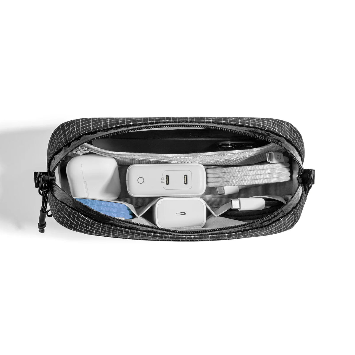 Black travel pouch with electronic accessories on a white background