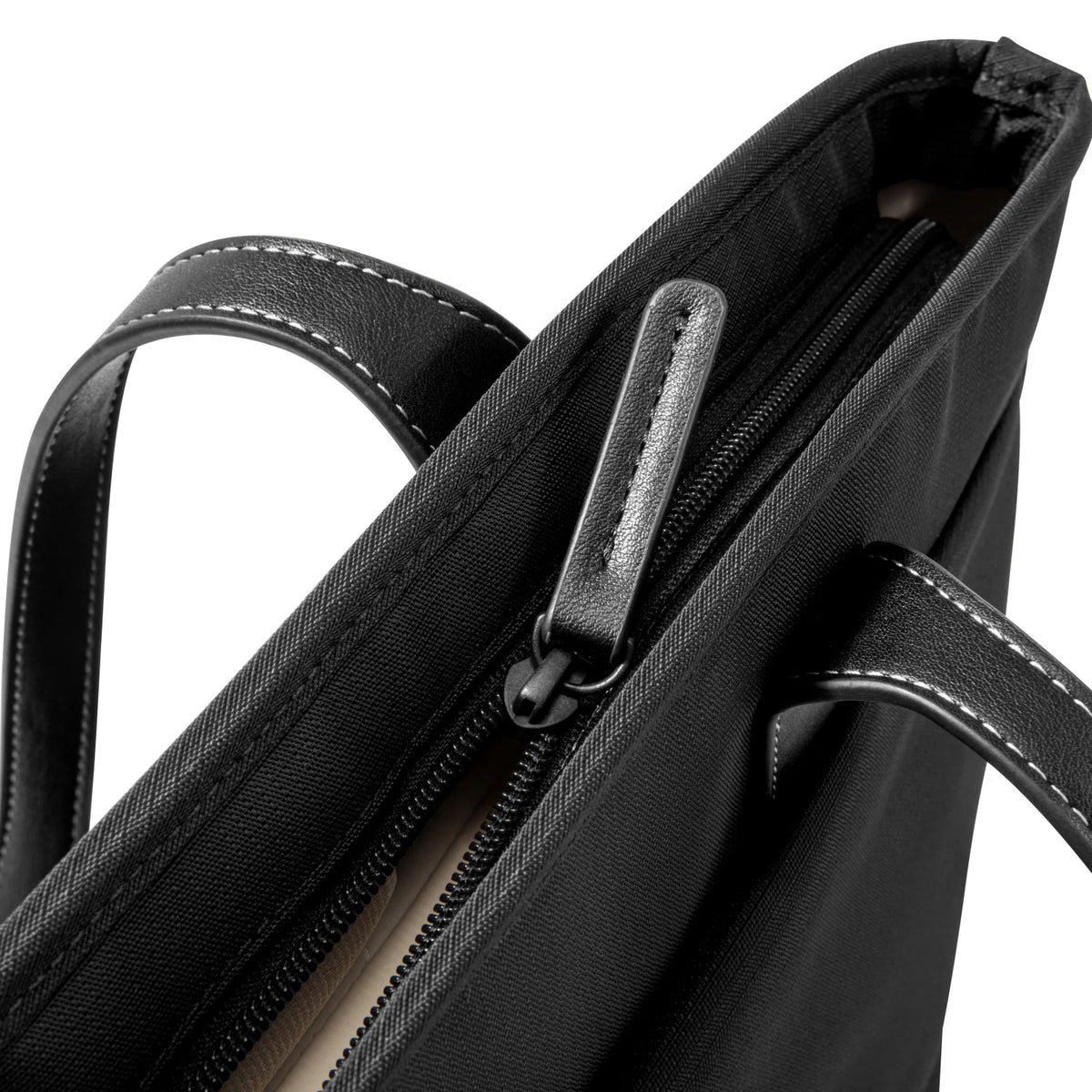 Close-up of a black handbag with a zipper and handle on a white background